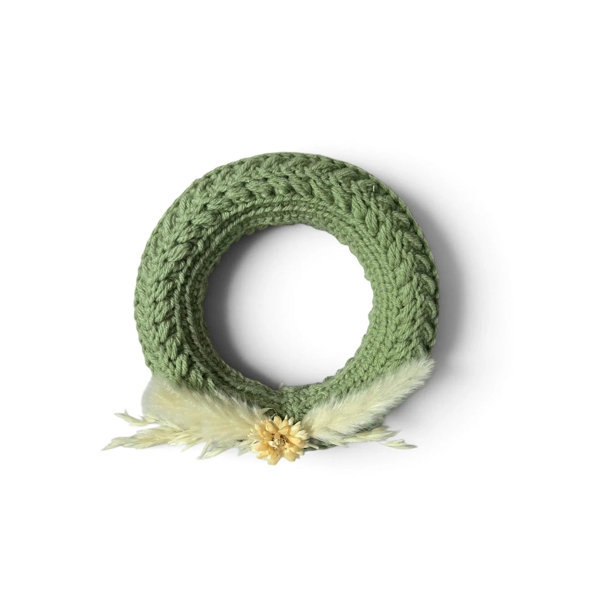 Handmade by Erika Liesel small green crochet wreath with dried floral accents and soft textured yarn detailing.