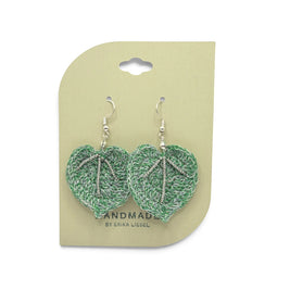 Handmade by Erika Liesel green heart-shaped crochet earrings with silver bead accents on a display card.