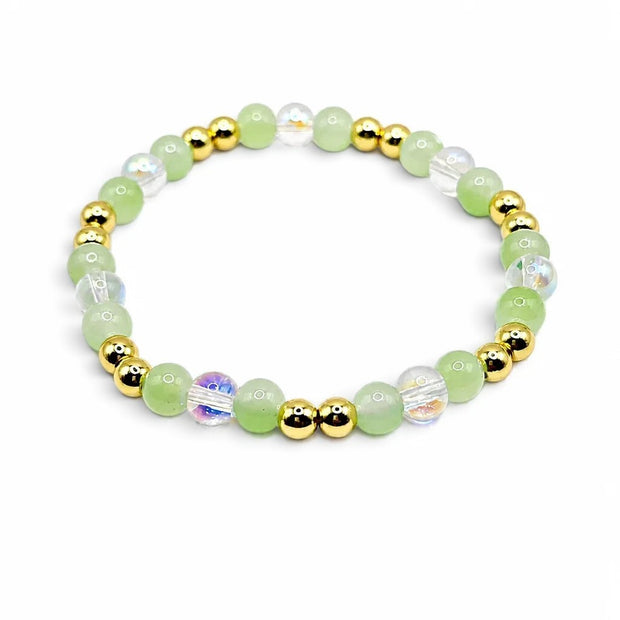 Handmade by Erika Liesel stretch bracelet featuring green glass beads, iridescent crystals, and 18K gold-plated accents.