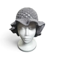 Handmade by Erika Liesel grey crochet bucket hat with a wide, wavy brim on a white mannequin head.