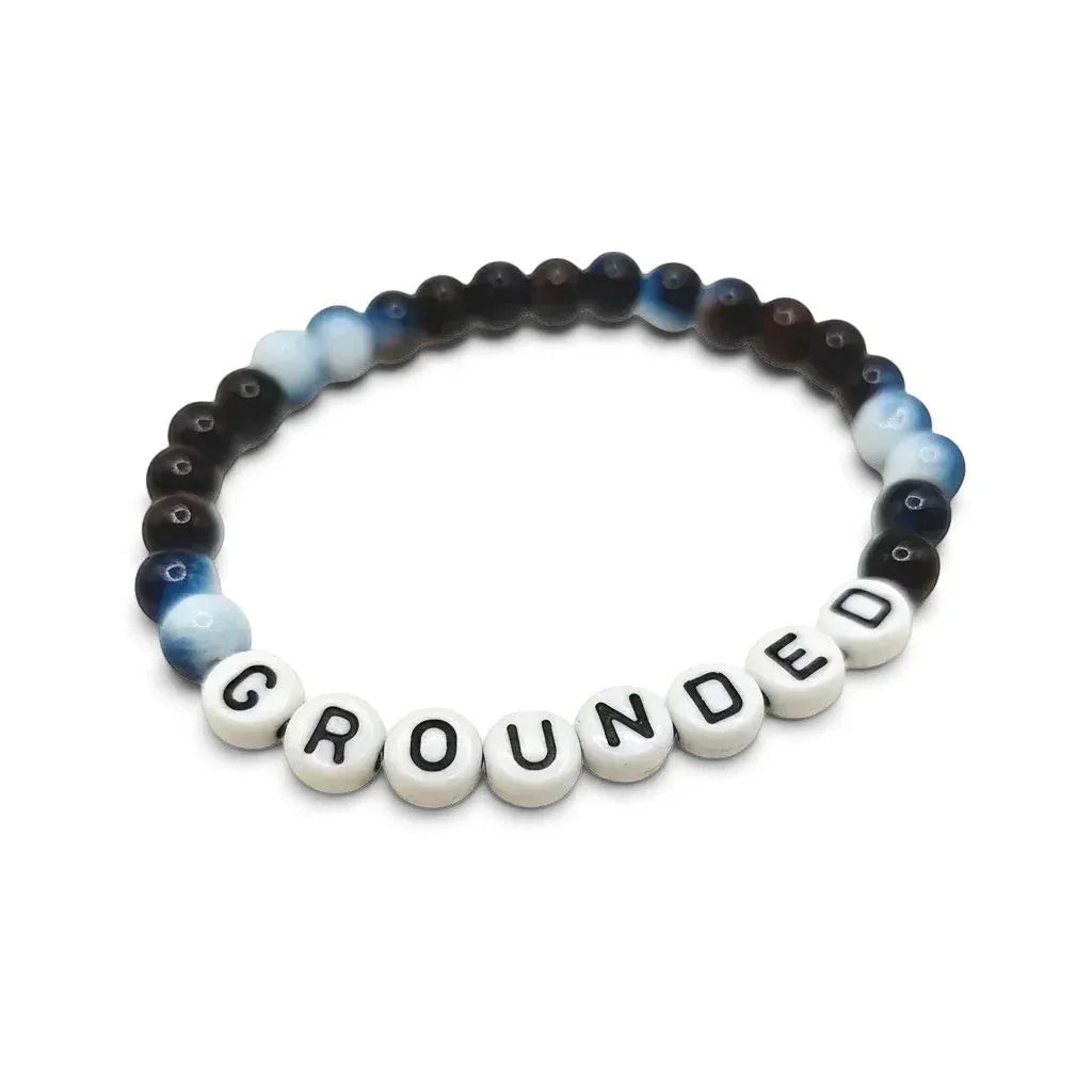 Handmade by Erika Liesel Grounded stretch bracelet featuring dark blue and brown glass beads with lettered beads