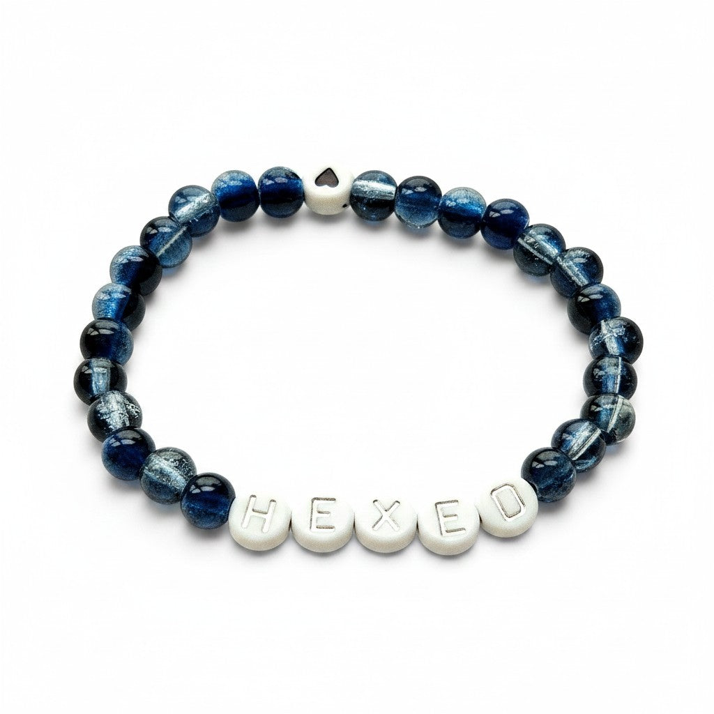Handmade by Erika Liesel Hexed stretch bracelet with midnight blue glass beads and silver lettered HEXED accents.