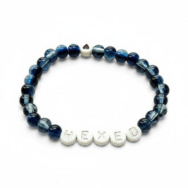 Handmade by Erika Liesel Hexed stretch bracelet with midnight blue glass beads and silver lettered HEXED accents.
