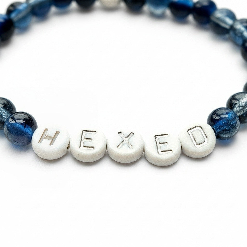 Handmade by Erika Liesel Hexed bracelet with midnight blue glass beads and white letter beads on elastic cord.