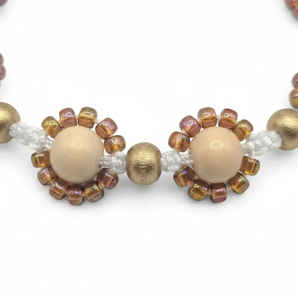 Handmade by Erika Liesel knotted bracelet featuring light wood beads, metallic gold accents, and iridescent glass beads