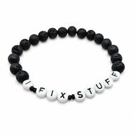 Handmade by Erika Liesel men's 8-inch stretch bracelet featuring matte black lava stone beads and I FIX STUFF text.