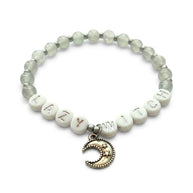 Handmade by Erika Liesel Lazy Witch bracelet with gray glass beads, silver letter beads, and a crescent moon charm.