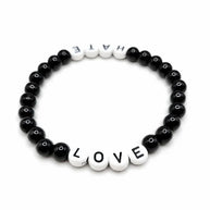 Handmade by Erika Liesel stretch bracelet with black glass beads and white letter beads spelling Love and Hate.