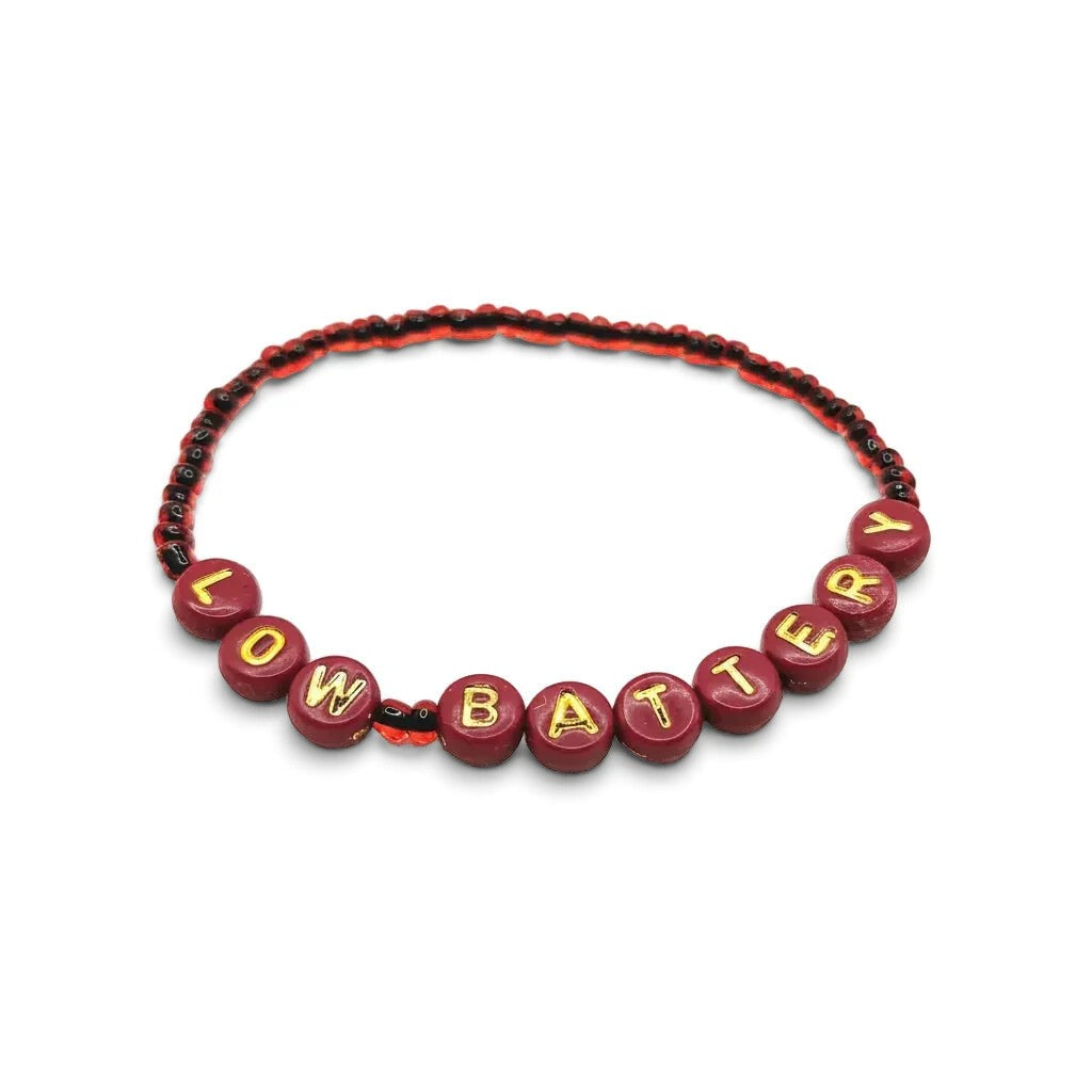 Handmade by Erika Liesel Low Battery stretch bracelet featuring red glass beads and gold-foil letter beads.