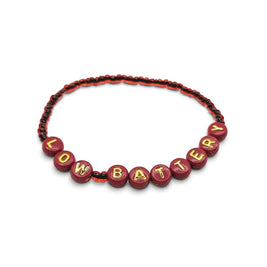 Handmade by Erika Liesel Low Battery stretch bracelet featuring red glass beads and gold-foil letter beads.
