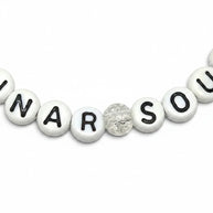 Handmade by Erika Liesel Lunar Soul stretch bracelet featuring white letter beads and a clear marbled glass bead.