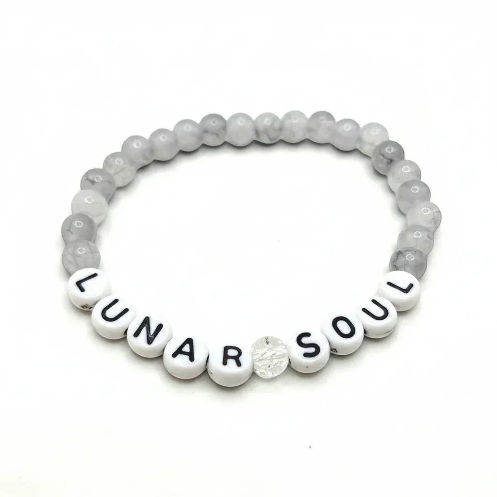Handmade by Erika Liesel Lunar Soul bracelet featuring gray marbled glass beads and white lettered accent beads.
