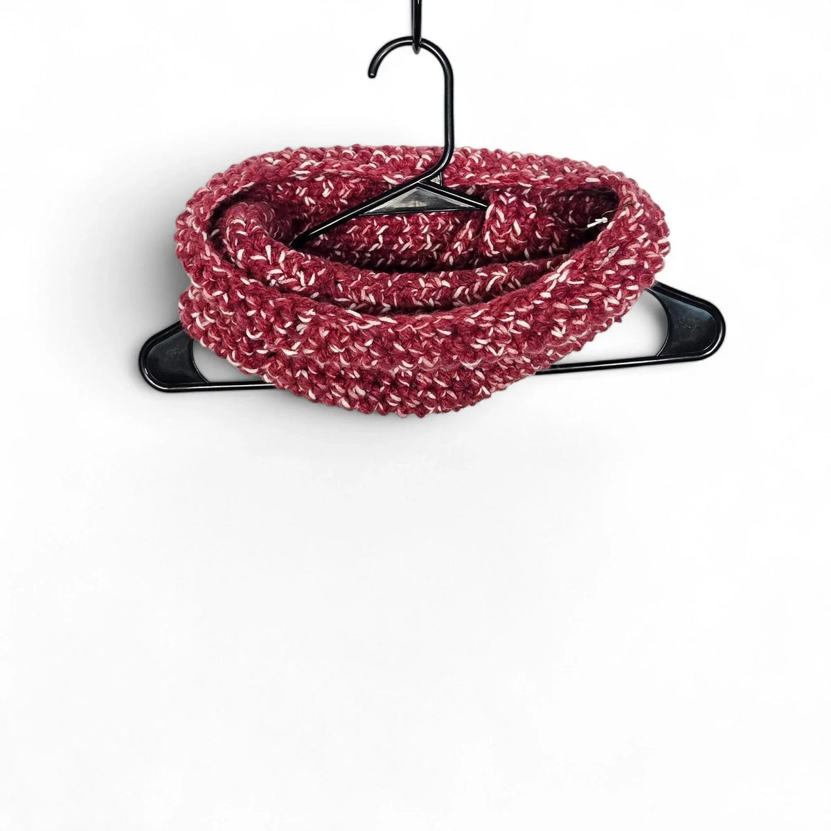 Handmade by Erika Liesel maroon and white variegated yarn crochet neck warmer hanging on a black hanger.