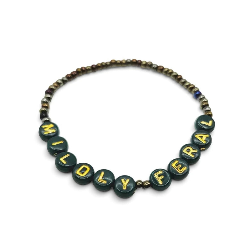 Handmade by Erika Liesel Mildly Feral stretch bracelet featuring dark green beads with gold letters and metallic accents