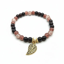 Handmade by Erika Liesel stretch bracelet with black, mulberry, and crackle glass beads and a gold-tone leaf charm.