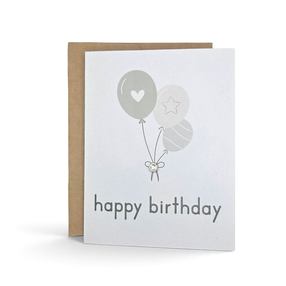 Handmade by Erika Liesel birthday card with neutral balloons, gemstone accent, and kraft envelope on white background