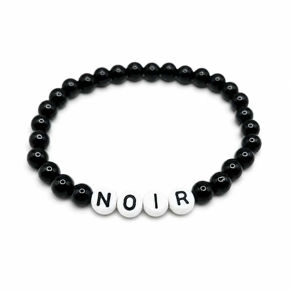 Handmade by Erika Liesel Noir bracelet featuring black glass beads and white letter beads on a stretch cord