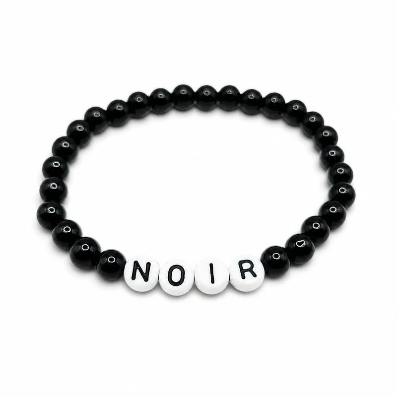 Handmade by Erika Liesel Noir bracelet featuring black glass beads and white letter beads on a stretch cord