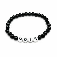 Handmade by Erika Liesel Noir bracelet featuring black glass beads and white letter beads on a stretch cord