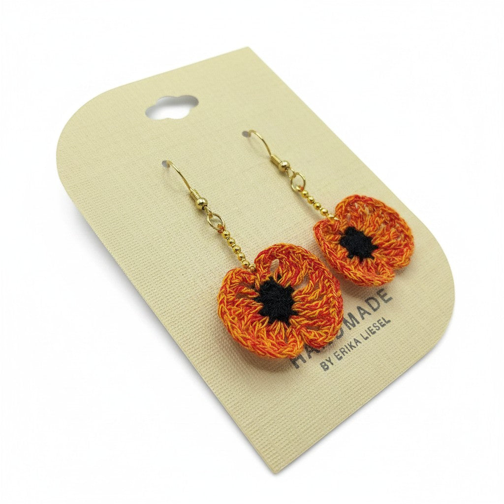Handmade by Erika Liesel orange crochet poppy flower earrings with black centers, glass beads, and gold hooks.