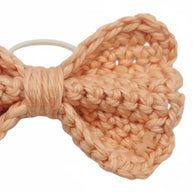 Handmade by Erika Liesel peach crochet bow hair tie with a soft yarn texture and durable elastic band