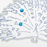 Handmade by Erika Liesel peacock greeting card with blue ink illustration, silver glitter accents, and gem details.