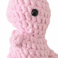 Handmade by Erika Liesel pink crochet dinosaur plushie made from soft chenille yarn with a black safety eye.
