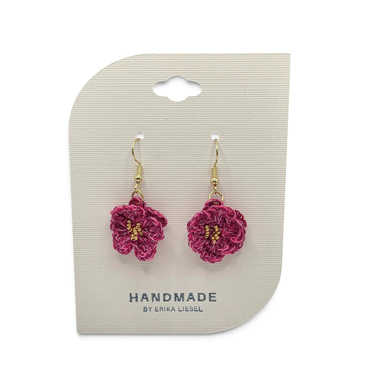 Handmade by Erika Liesel Bloom crochet flower earrings in deep pink with gold bead accents on a display card.