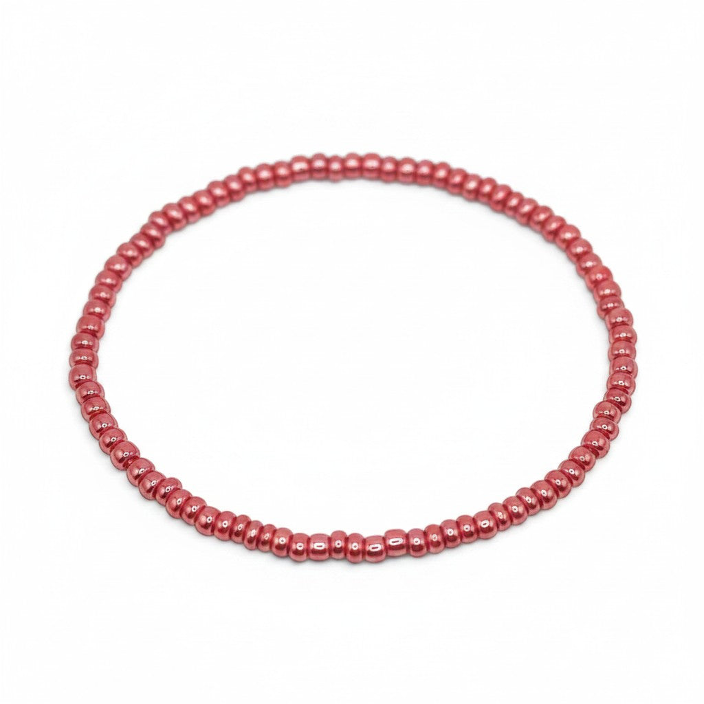 Handmade by Erika Liesel pink glass bead stretch bracelet with a glossy finish on a white background.