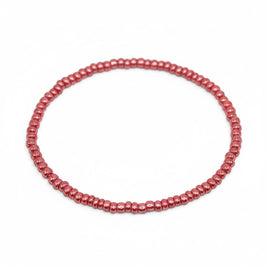 Handmade by Erika Liesel pink glass bead stretch bracelet with a glossy finish on a white background.