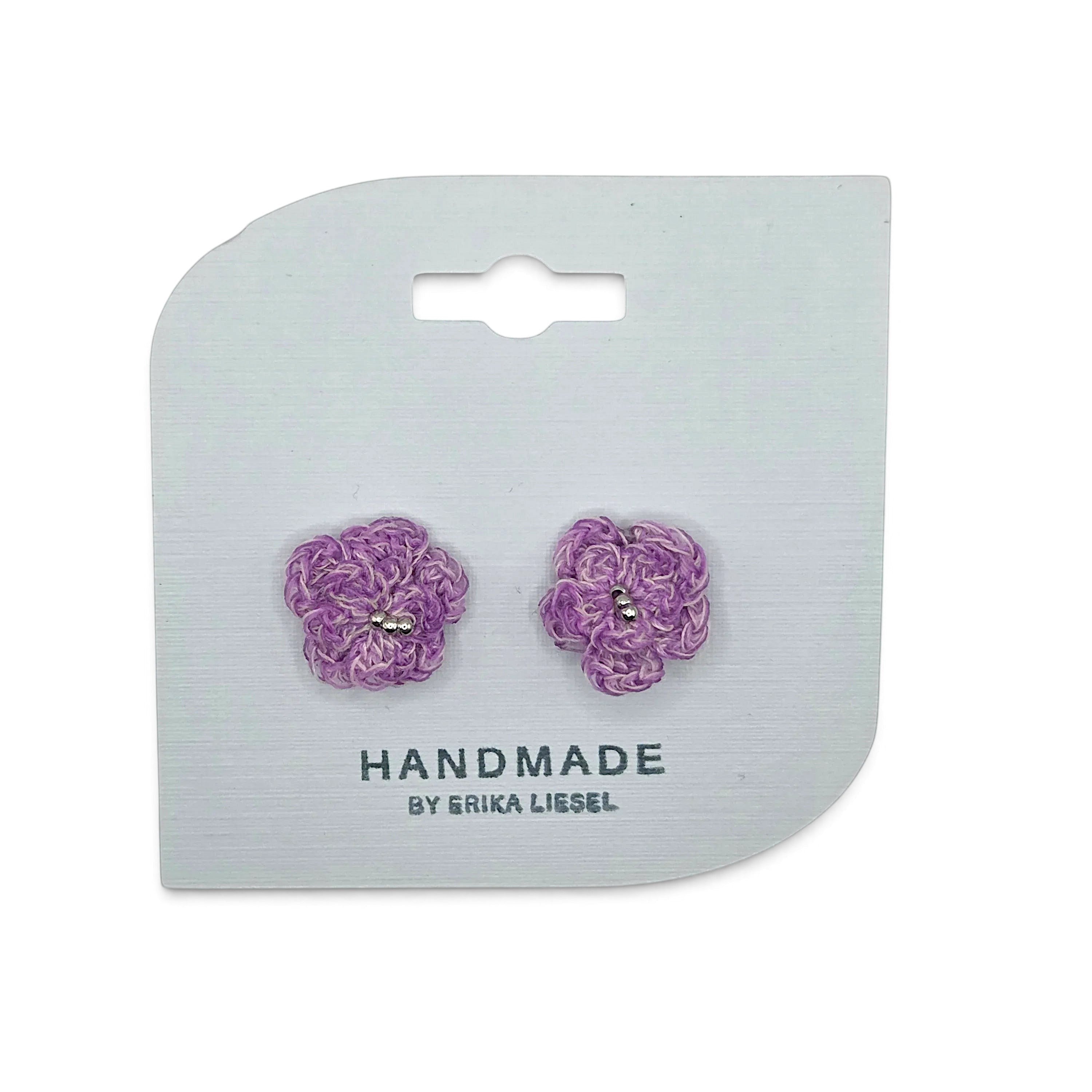 Handmade by Erika Liesel Bloom crochet flower earrings in purple with delicate bead accents on a display card.