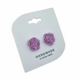 Handmade by Erika Liesel purple crochet flower stud earrings with delicate glass bead centers on a display card.