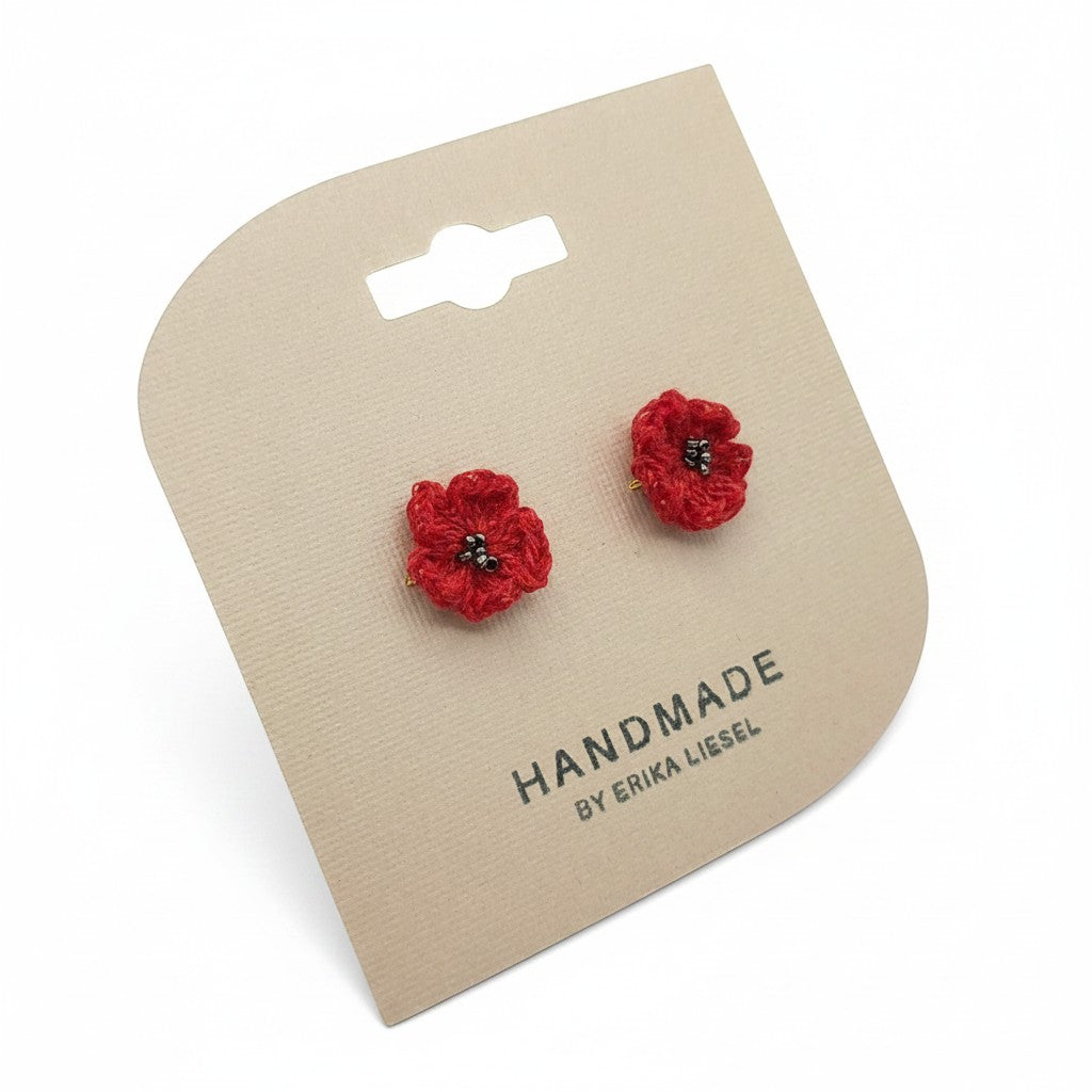 Handmade by Erika Liesel scarlet red crochet flower stud earrings with delicate glass bead centers on display card.