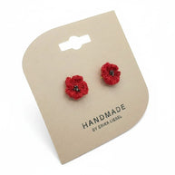 Handmade by Erika Liesel scarlet red crochet flower stud earrings with delicate glass bead centers on display card.