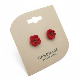 Handmade by Erika Liesel scarlet red crochet flower stud earrings with delicate glass bead centers on display card.