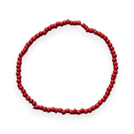 Handmade by Erika Liesel red glass bead stretch bracelet with a polished finish on a rustic wooden surface.
