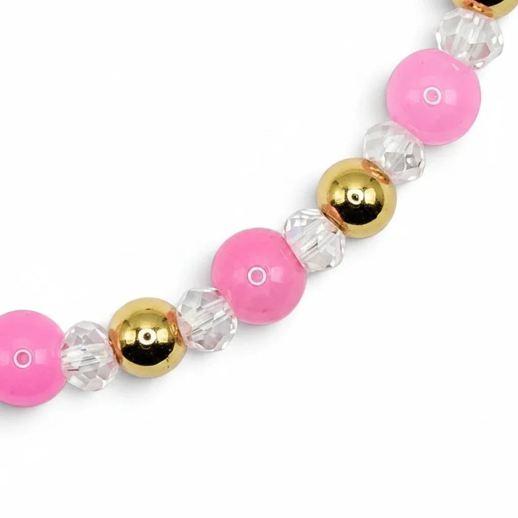 Handmade by Erika Liesel stretch bracelet featuring pink glass beads, clear crystal accents, and 18K gold-plated beads.