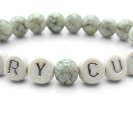 Handmade by Erika Liesel Scary Cute bracelet with gray marbled glass beads and white letter beads on elastic cord