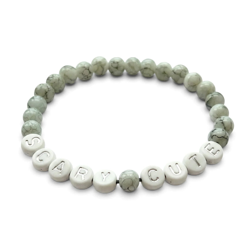 Handmade by Erika Liesel Scary Cute bracelet featuring gray marbled glass beads and silver lettered accent beads.