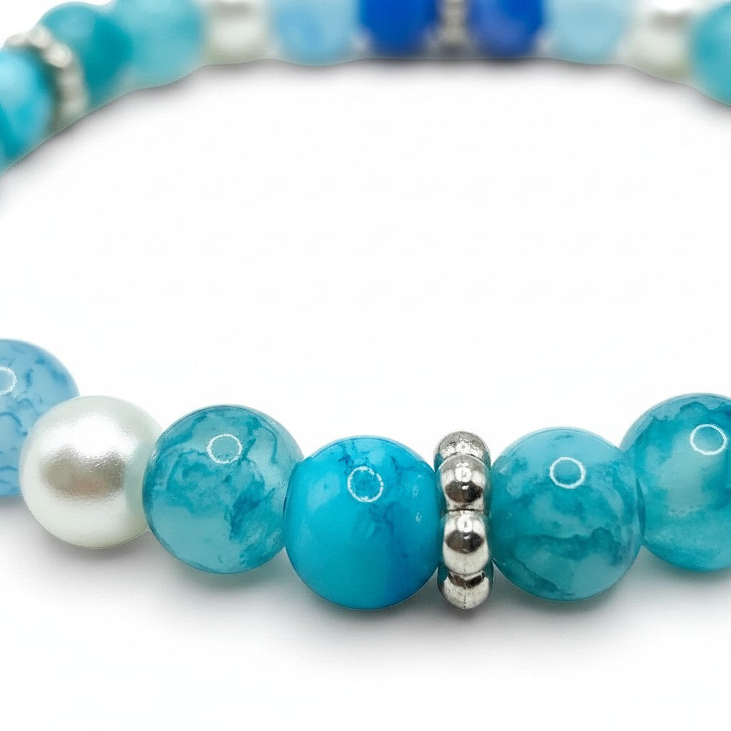 Handmade by Erika Liesel Sea Mist stretch bracelet featuring aqua glass beads, faux pearls, and silver spacer beads.
