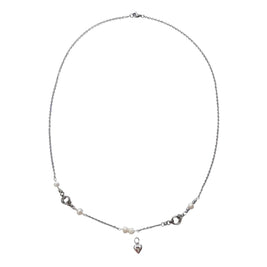 A delicate silver chain necklace with small white pearl-like beads and a small silver heart charm, displayed on a white card.