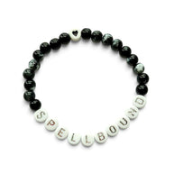 Handmade by Erika Liesel Spellbound stretch bracelet with glossy black glass beads and silver lettered beads.