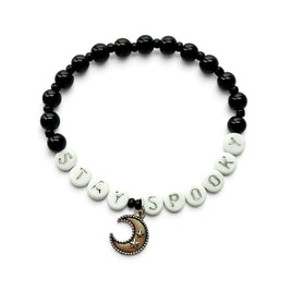 Handmade by Erika Liesel Stay Spooky bracelet with black glass beads, white letter beads, and a crescent moon charm.