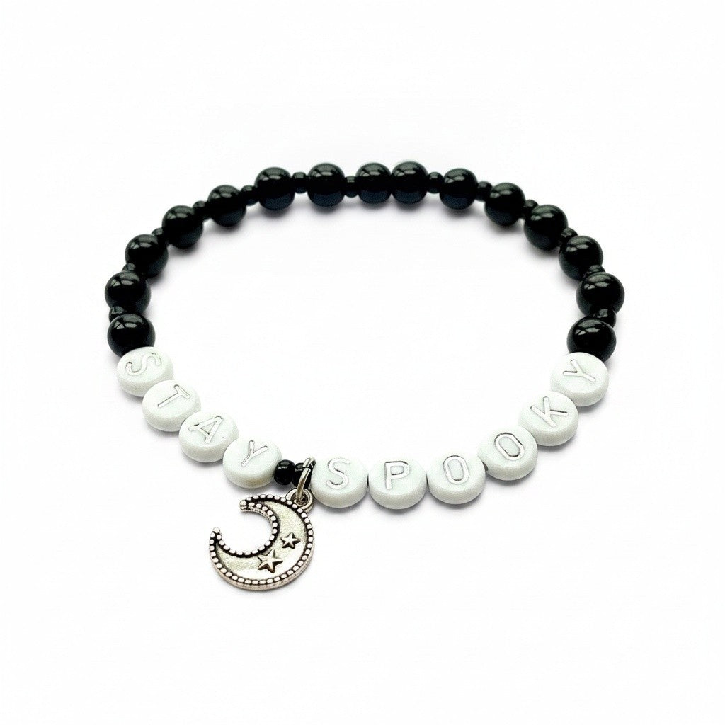 Handmade by Erika Liesel Stay Spooky bracelet with black glass beads, white letter beads, and a silver moon charm.