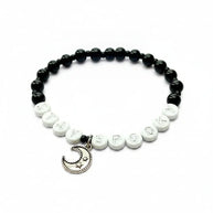 Handmade by Erika Liesel Stay Spooky bracelet with black glass beads, white letter beads, and a silver moon charm.