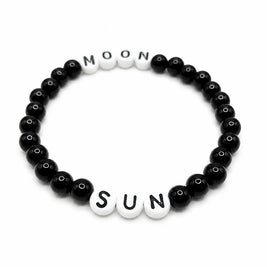 Handmade by Erika Liesel Sun & Moon stretch bracelet with black glass beads and white letter beads on elastic cord.