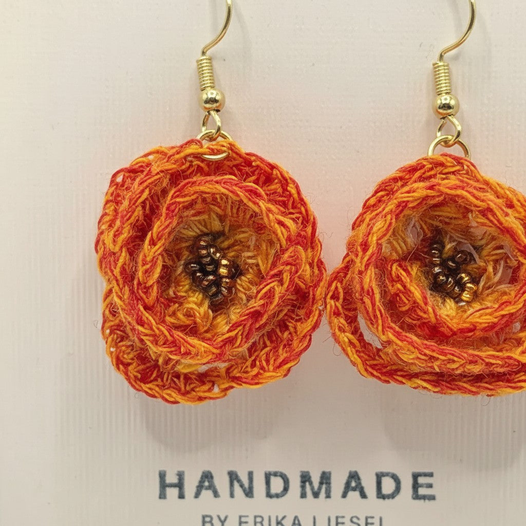 Handmade by Erika Liesel tangerine orange crochet flower earrings with gold hardware and central glass bead detail.
