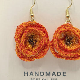 Handmade by Erika Liesel tangerine orange crochet flower earrings with gold hardware and central glass bead detail.