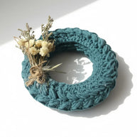 Handmade by Erika Liesel mini crochet wreath in teal with delicate dried floral accents for home decor styling.