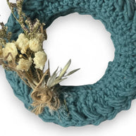 Handmade by Erika Liesel teal crochet mini wreath decorated with dried cream flowers and natural twine accents.